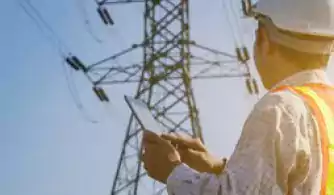 Electrical engineer with tablet inspecting electrical tower.jpg