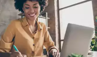 Young woman taking notes during remote meeting