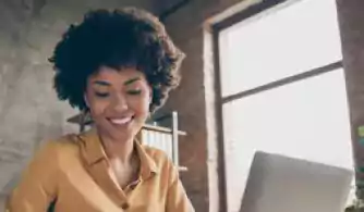 Young woman taking notes during remote meeting