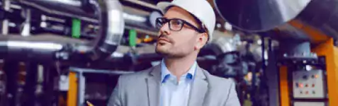 Man in hard hat reviewing power plant