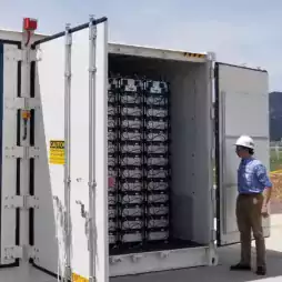Worker showing insides of energy storage container