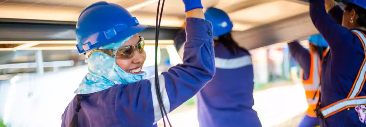 people - smiling worker in hard hat with others colombia