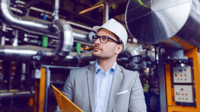 Man in hard hat reviewing power plant