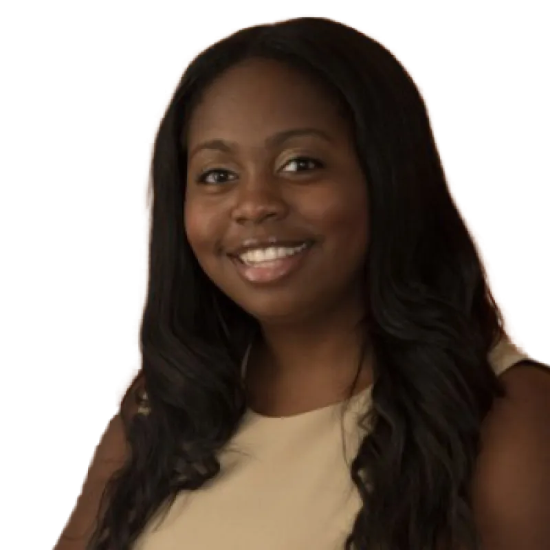 Portrait of Erica Harris smiling, wearing a beige sleeveless top. She has long, dark, wavy hair. Her expression is warm and approachable, conveying a professional and friendly demeanor.