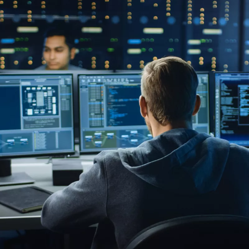 man viewing computer screens