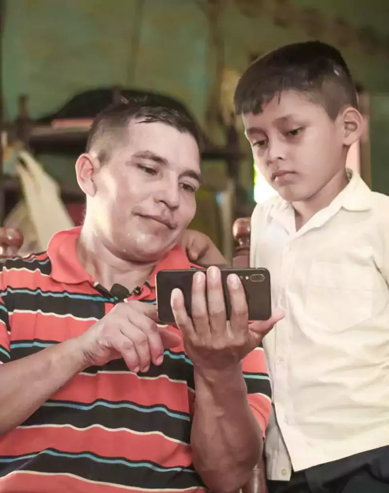 Man sharing content on his phone with a boy