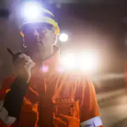 impact - man in orange coat with walkie talkie