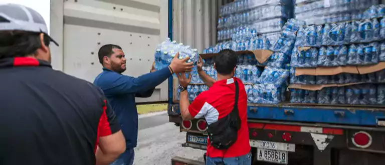 Hurricane Relief Workers Sharing Water Bottles