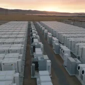 Aerial view of AES battery energy storage containers at a California facility during sunset, with open landscape in the background.