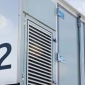 A close-up view of an Advancion Energy Storage unit with the number 312 displayed prominently. The unit features a logo and ventilation panels. The sky is partly cloudy in the background.