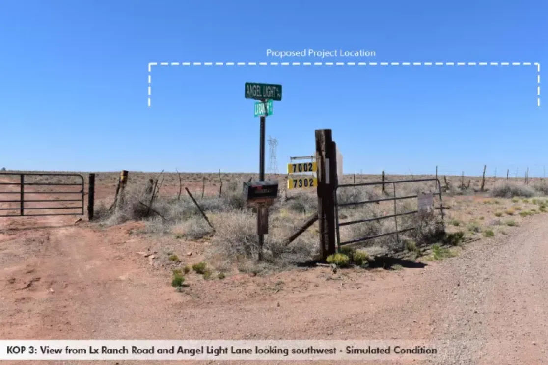 Rural intersection with dirt roads, a gate, and signs for Angel Light Lane and Lx Ranch Road. A dashed line indicates a proposed project location in the distance under a clear blue sky.