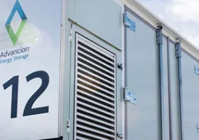 Close-up of Advancion Energy Storage units with the number 312 on a sunny day with clouds in the sky.