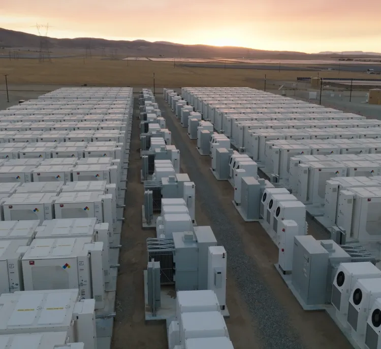 Aerial view of AES battery energy storage containers at a California facility during sunset, with open landscape in the background.