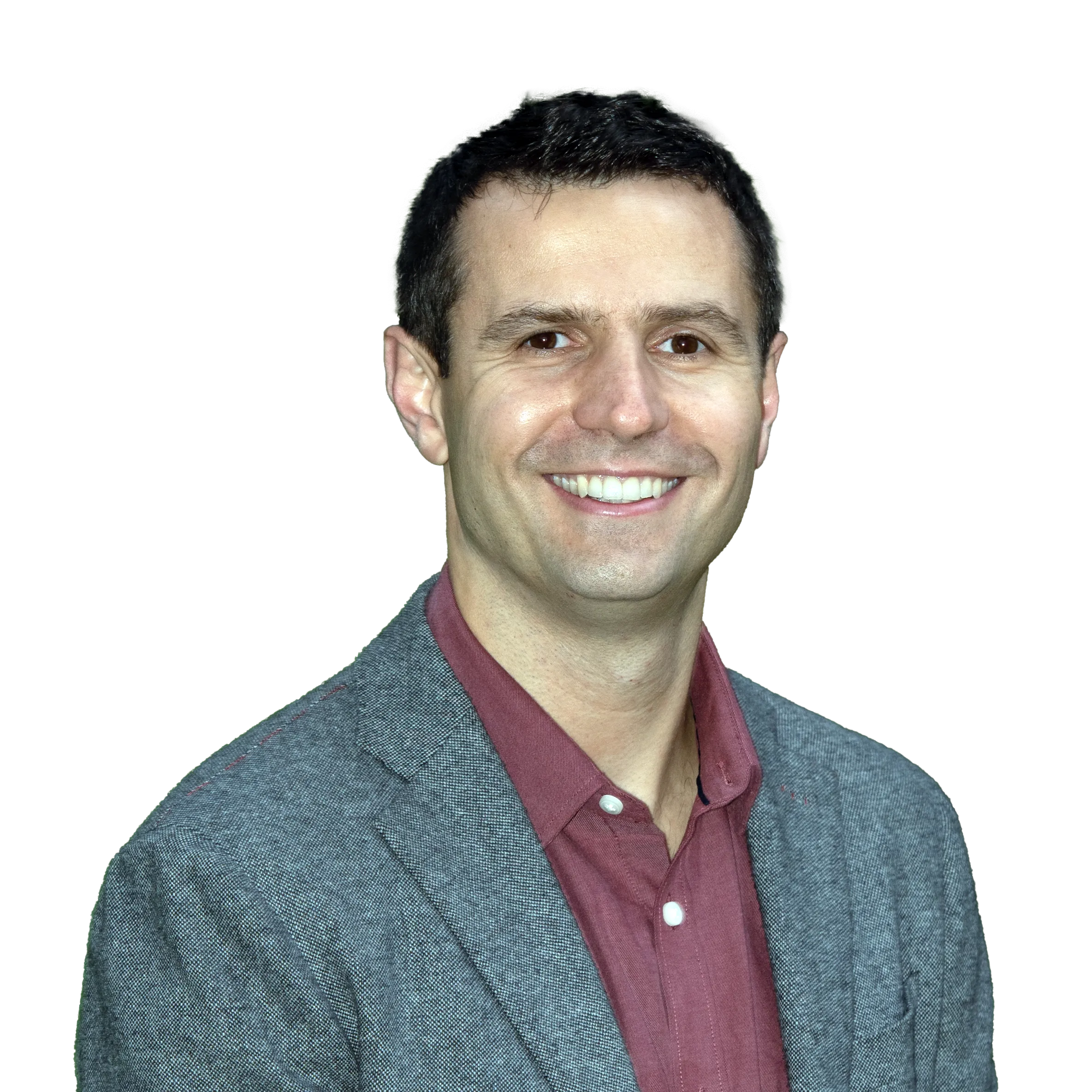 Smiling man in a gray blazer and maroon shirt against a black background.