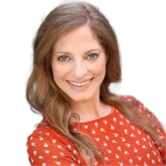 Smiling woman with long light brown hair wearing an orange patterned blouse.