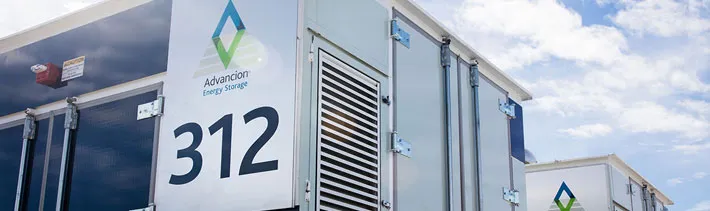Close-up of Advancion Energy Storage units with the number 312 on a sunny day with clouds in the sky.