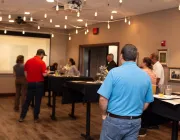 Group of people watching a presentation at the front of the room.