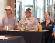 A group of people standing around a high-top table.